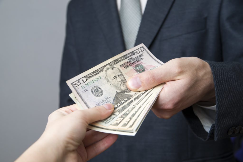 Man in Suit reluctantly giving money