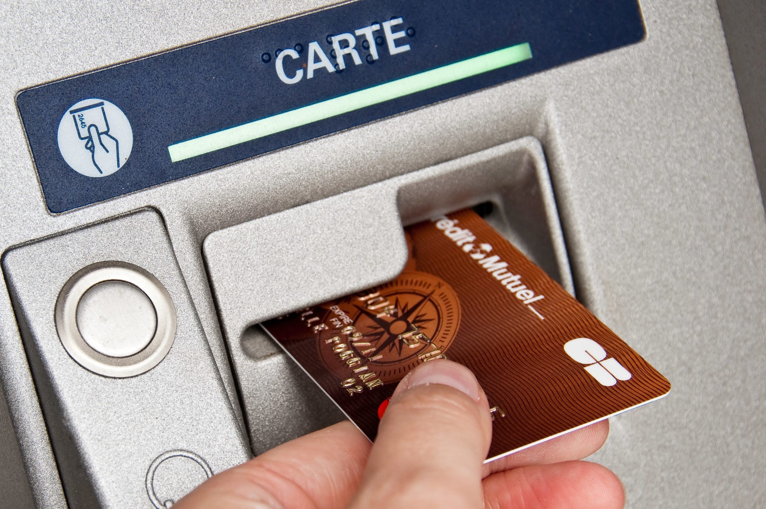 hand inserting french credit card into atm