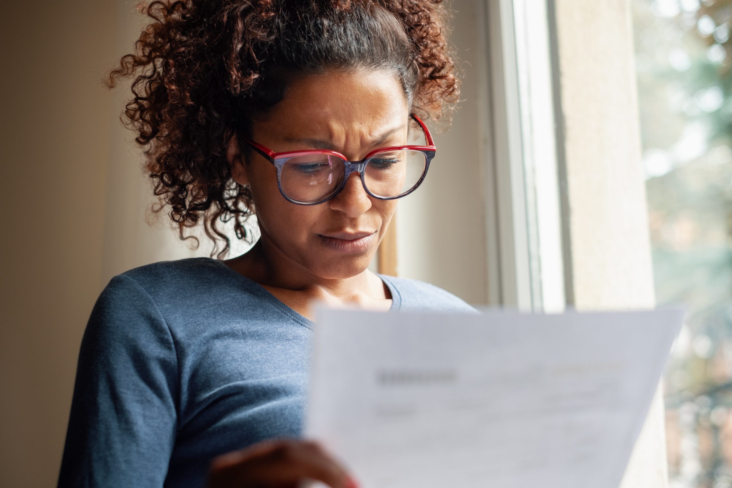 frustrated black woman reading bank statement